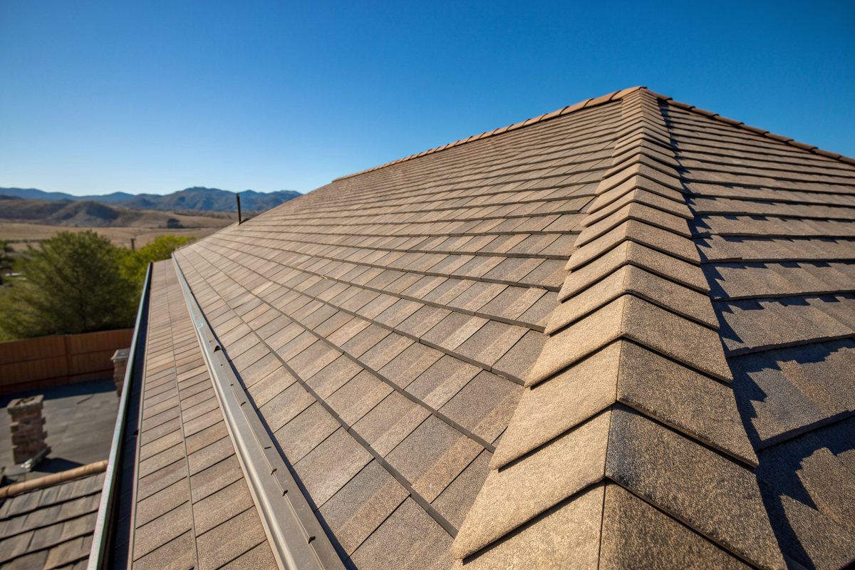 New architectural shingles meeting at a ridge vent on a freshly replaced roof