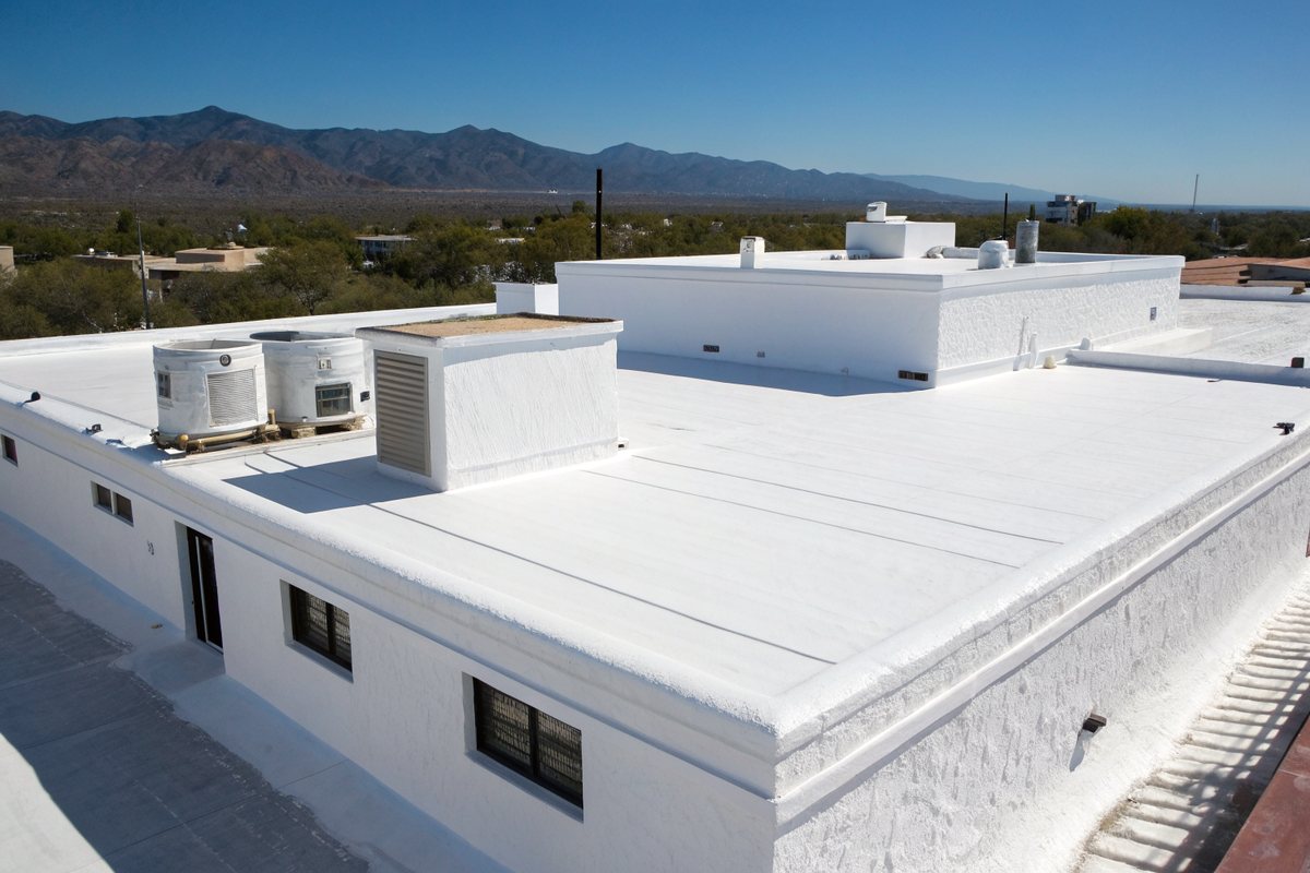 A flat roof with a fresh bright white coating and a rooftop cooler